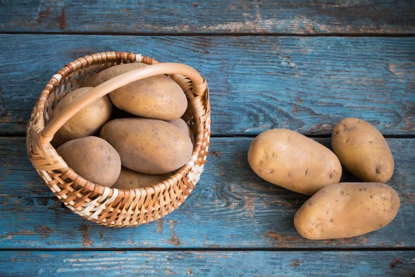 Eski mavi ahşap arka plan üzerinde patates — Stok fotoğraf