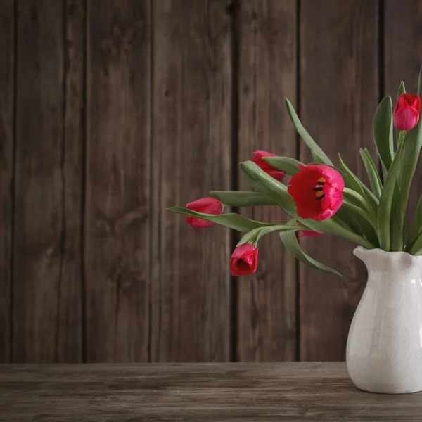 Bukiet czerwonych tulipanów na podłoże drewniane — Zdjęcie stockowe