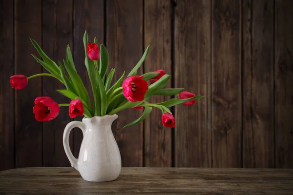 Bukiet czerwonych tulipanów na podłoże drewniane — Zdjęcie stockowe