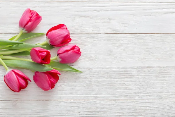 Růžové tulipány na bílém pozadí dřevěná — Stock fotografie