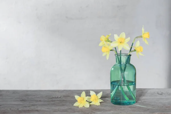 Narciso amarillo en jarrón en pared de madera vieja — Foto de Stock