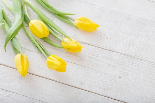 Жовті тюльпани на білому дерев'яному фоні — стокове фото
