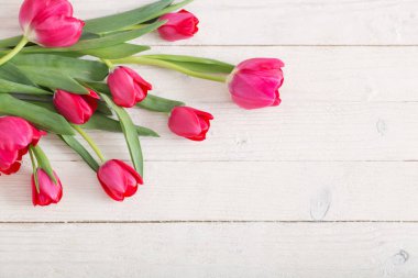 Beyaz ahşap zemin üzerinde pembe laleler