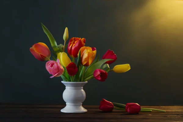 Beautiful tulips in vase on green background — Stock Photo, Image
