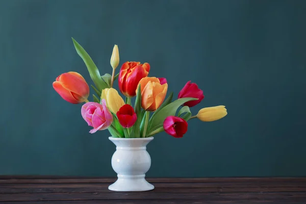 Piękne tulipany w wazonie na zielonym tle — Zdjęcie stockowe