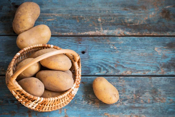Aardappelen op oude blauwe houten achtergrond — Stockfoto