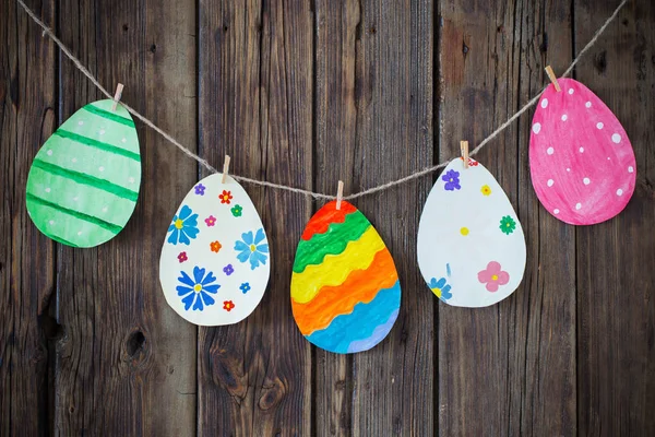 Papel de Pascua pintados huevos pintados cuelgan en pinzas de ropa en backgr —  Fotos de Stock