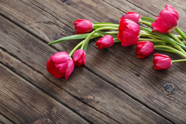 Red tulips on dark wooden background — Stock Photo, Image