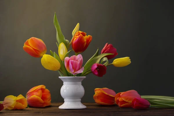 Schöne Tulpen in der Vase auf grünem Hintergrund — Stockfoto