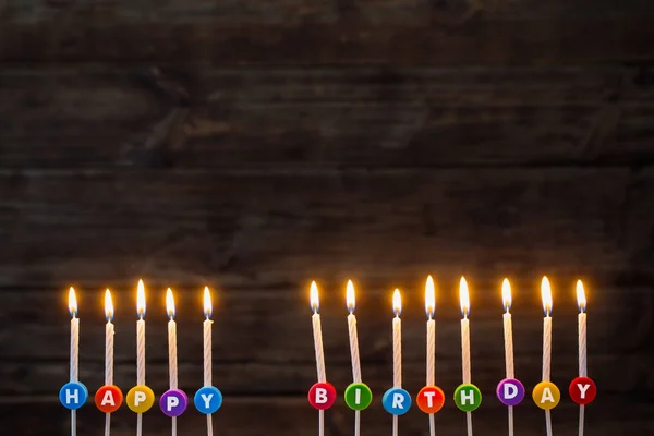 Velas de cumpleaños sobre fondo de madera oscura — Foto de Stock