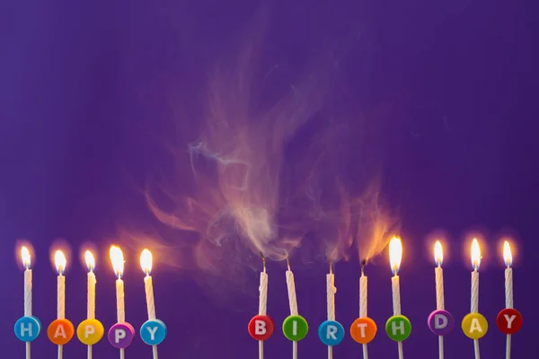 Velas de aniversário no fundo violeta — Fotografia de Stock