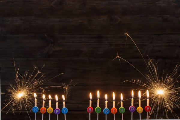 Velas de cumpleaños sobre fondo de madera oscura — Foto de Stock