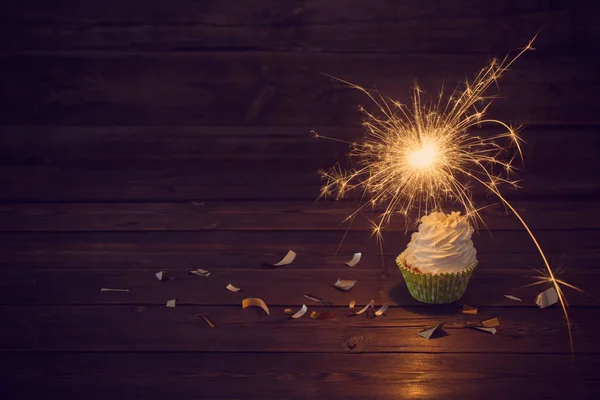 Bolo de aniversário com sparkler no fundo de madeira velha — Fotografia de Stock