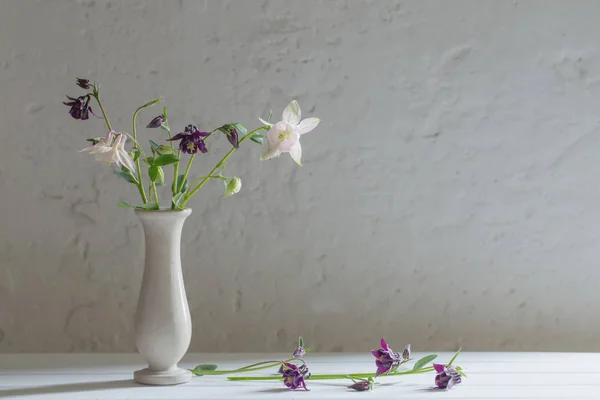 Flowers in vase on background old white wall — Stock Photo, Image