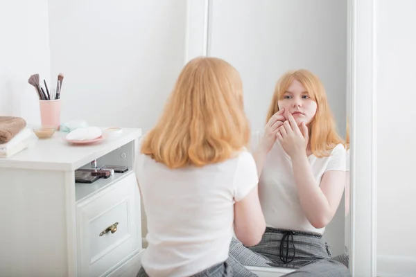 Teen girl examines acne in front of mirror — Stock Photo, Image