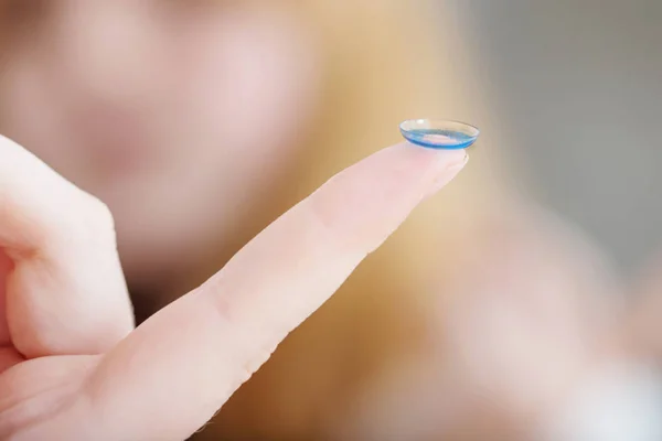 Blauw oog lens op vinger — Stockfoto