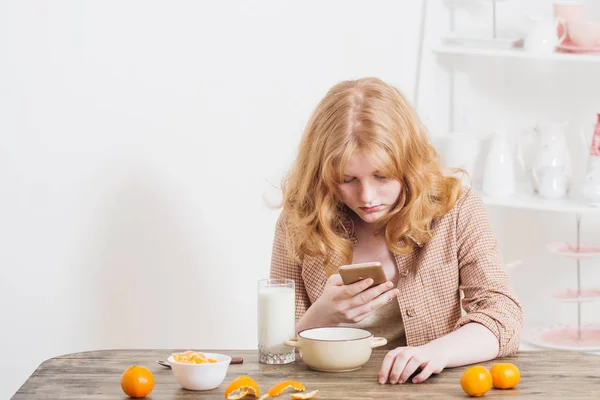 Подростковая девочка и здоровый завтрак с овсянкой и мандаринами — стоковое фото