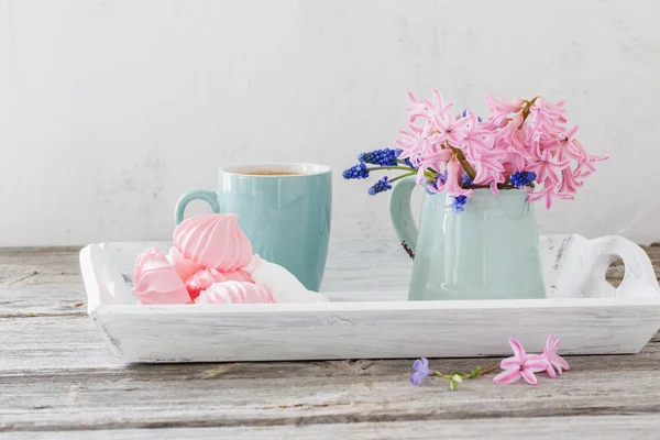 Une tasse de café et un bouquet de fleurs sur une table en bois — Photo