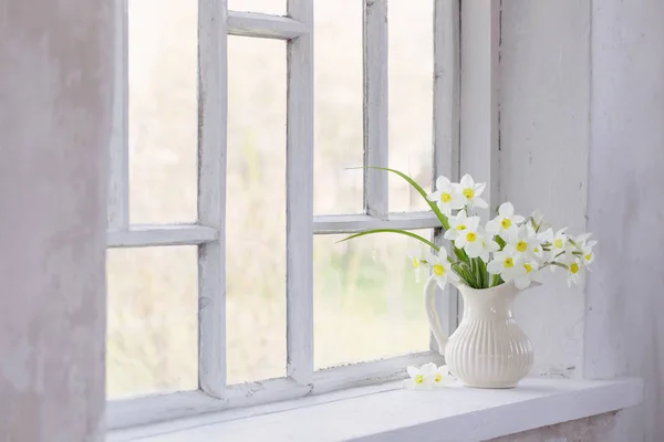 Narcisos en jarra sobre alféizar de ventana — Foto de Stock