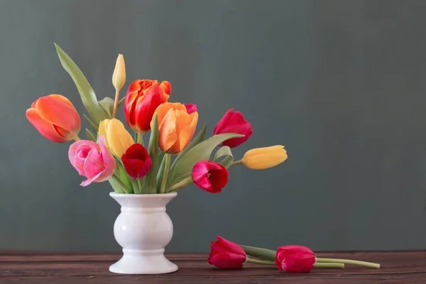 Belas tulipas em vaso no fundo verde — Fotografia de Stock