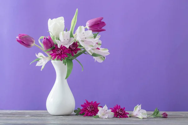 Beautiful spring flowers in white vase — Stock Photo, Image