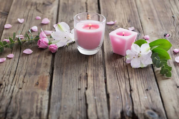 Candele rosa e fiori su sfondo di legno — Foto Stock