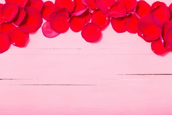 木製の背景に赤いバラの花びら — ストック写真