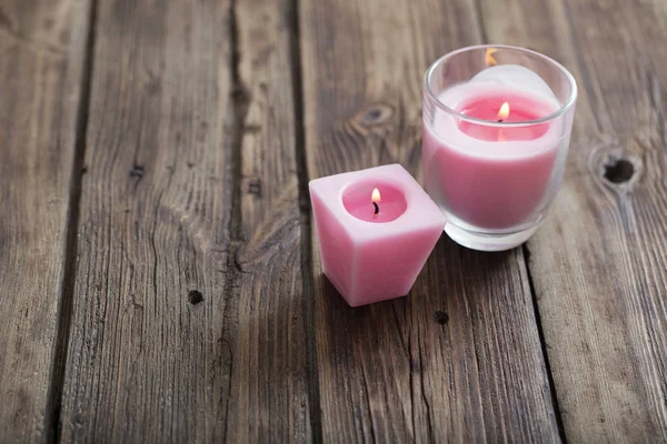 Ροζ κεριά στο παλιό ξύλινο υπόβαθρο — Φωτογραφία Αρχείου