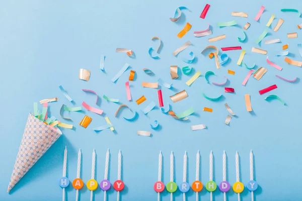 Birthday hat with confetti and candles  on paper background — Stock Photo, Image