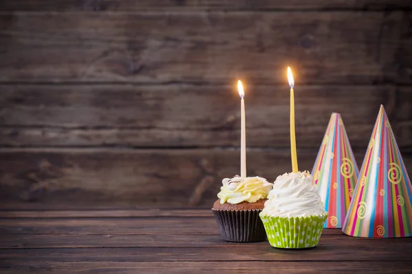 Birthday cupcakes med ljusen på gamla mörka trä bakgrund — Stockfoto