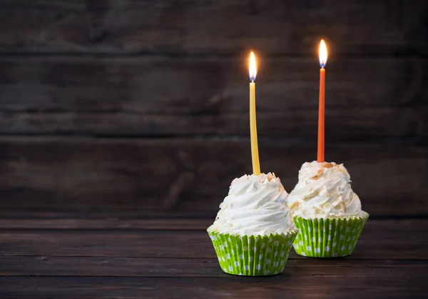 Urodziny cupcakes ze świecami na stary ciemne podłoże drewniane — Zdjęcie stockowe