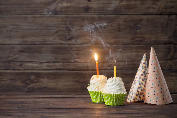 Cupcakes de cumpleaños con velas sobre fondo viejo de madera oscura —  Fotos de Stock