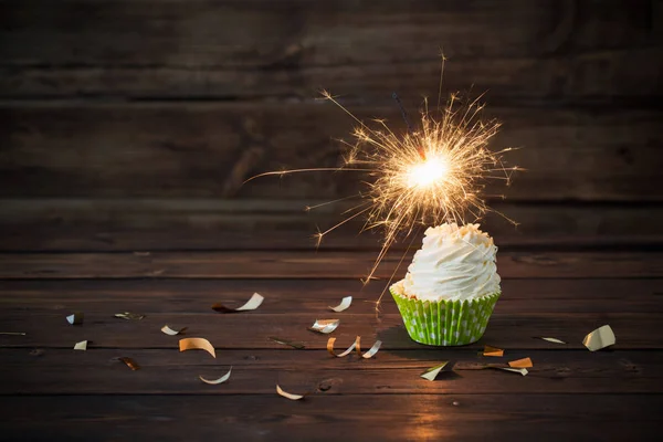 Birthday cake with sparkler on old wooden background — Stock Photo, Image