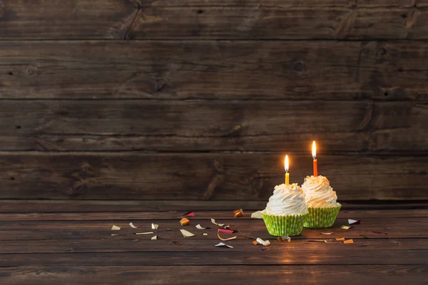 Verjaardag cupcakes met kaarsen op oude donkere houten achtergrond — Stockfoto