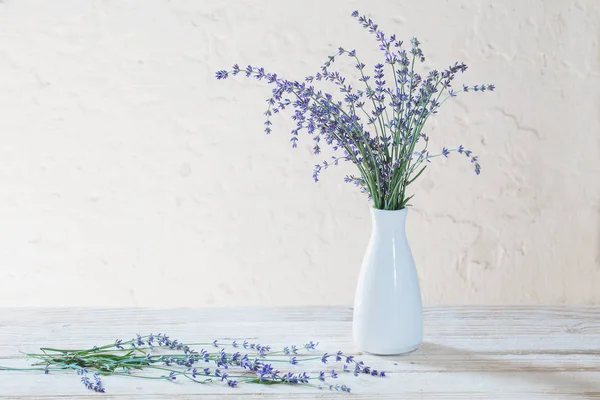 나무 테이블에 흰색 꽃병에 라벤더 — 스톡 사진
