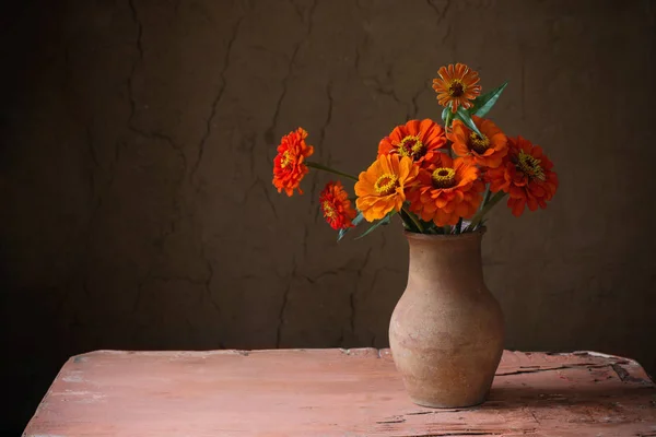 Квіти в глечику на старому дерев'яному столі — стокове фото