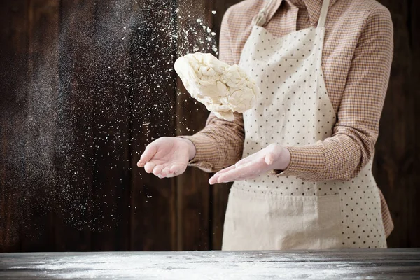 Mãos cozinhando massa no fundo de madeira escura — Fotografia de Stock
