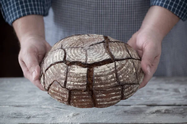 Händer med bröd på trä bakgrund — Stockfoto