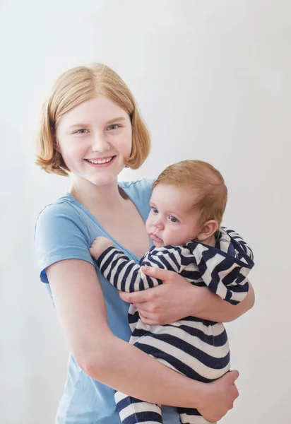 Older sister and younger brother on white background — Stock Photo, Image