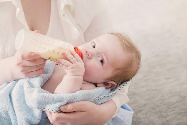 Маленька дитина їсть молоко з пляшки — стокове фото