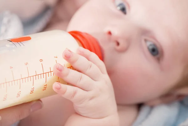 병에서 우유를 먹고 작은 아기 — 스톡 사진