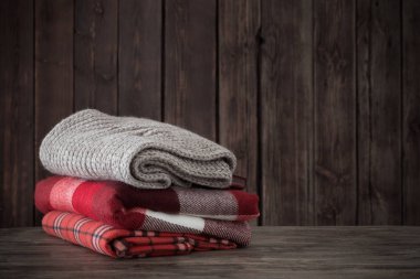 ahşap arka planda İskoç şalılar yığını