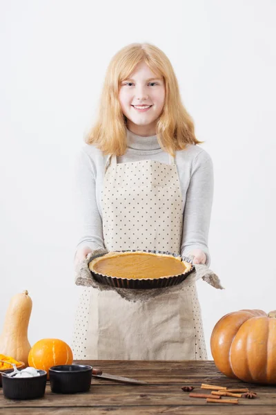 Έφηβος κορίτσια μαγειρεύει κολοκύθα πίτα σε λευκό φόντο — Φωτογραφία Αρχείου