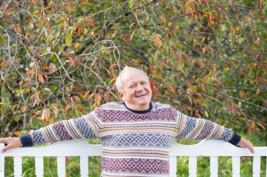 sonbahar Park beyaz bankta oturan yaşlı adam