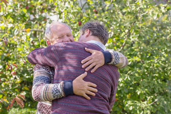 Two men hugging in autumn park — Stock Photo, Image