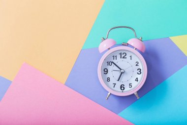 Pastel kağıt arka planında alarm saati