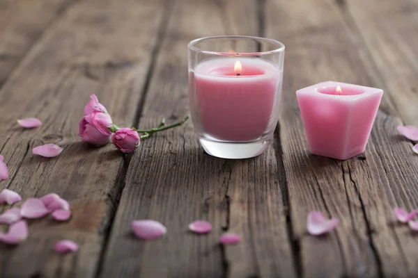 Свічки і троянди на дерев'яному фоні — стокове фото