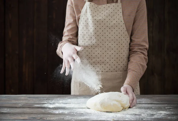 Mãos cozinhando massa no fundo de madeira escura — Fotografia de Stock