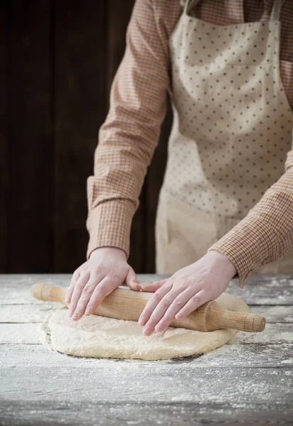 Mãos cozinhando massa no fundo de madeira escura — Fotografia de Stock