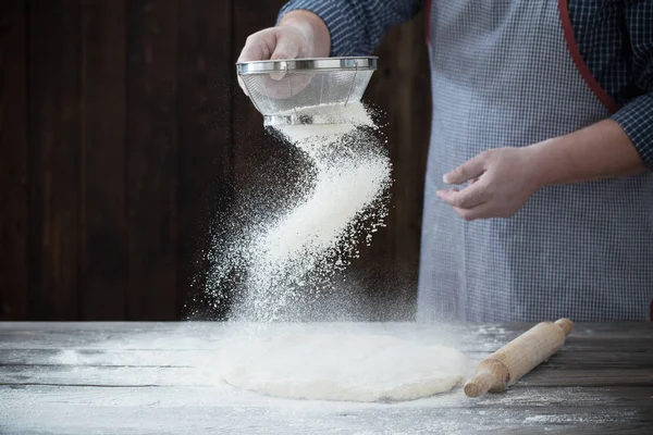 Руки готують тісто на темному дерев'яному фоні — стокове фото